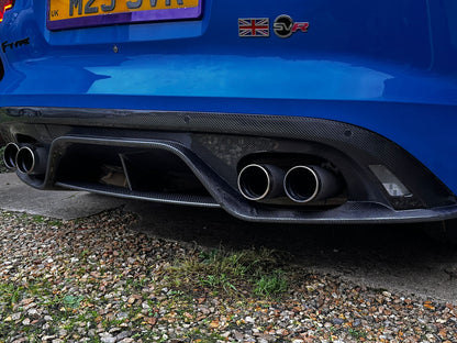 Blue jaguar with carbon fiber exhaust system on a gravel surface