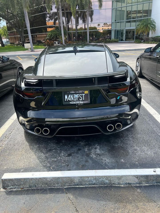 Rear view of a black Jaguar F Type with a carbon fibre spoiler pack installed on the vehicle.