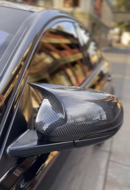 Carbon fiber car mirror on a vehicle with blurred background