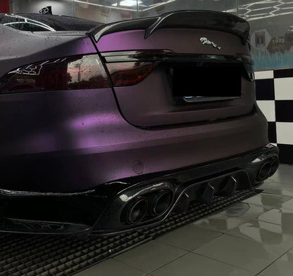 A Jaguar XE car with a trunk boot spoiler installed, finished in gloss black.