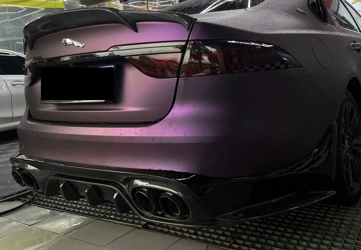 rear side view of a purple wrapped jaguar xe with rear boot spoiler carbon fiber and rear carbon fiber diffuser