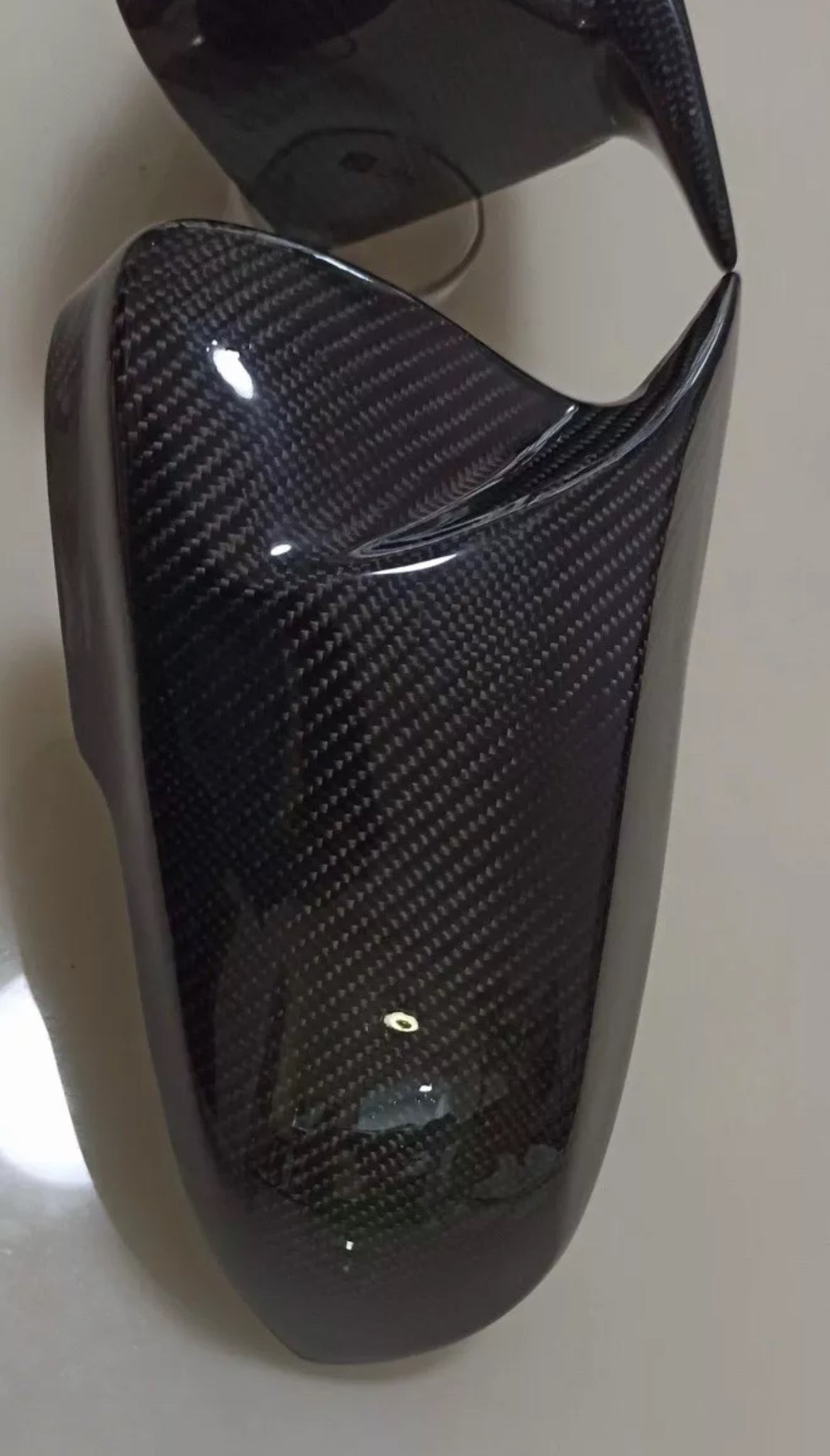 Carbon fiber-textured mirror cover on a white background