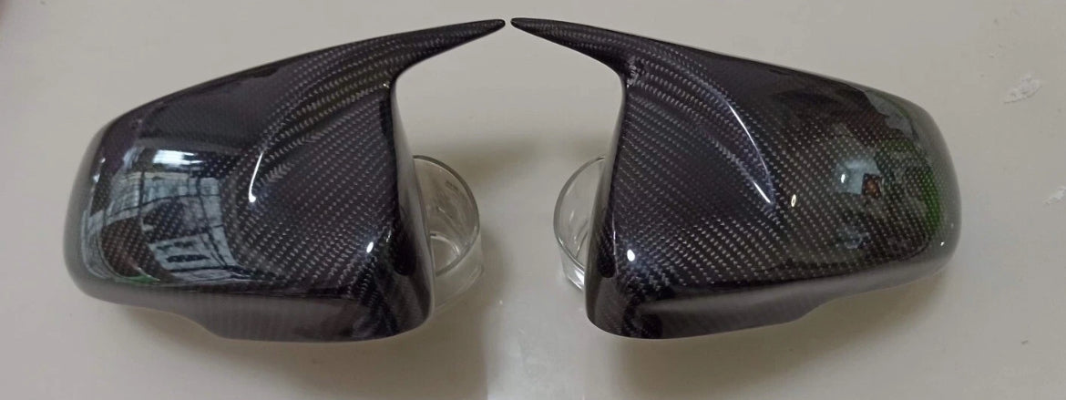 Carbon fiber car mirror covers on a white background