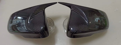Carbon fiber car mirror covers on a white background