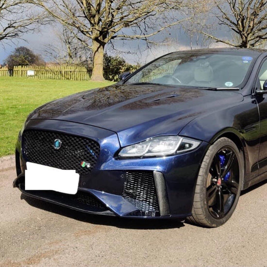A Jaguar XJ X351 VRS BodyKit Upgrade Conversion installed on a blue Jaguar XJ, featuring a front bumper with carbon lip splitter, mesh grille inserts, and stainless steel quad exhaust tips.